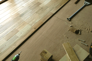 一番大変だったという床板張り作業。継ぎ目が重ならないように計算しながら木材をカットし、敷き詰めていく（平成25年7月ごろ）